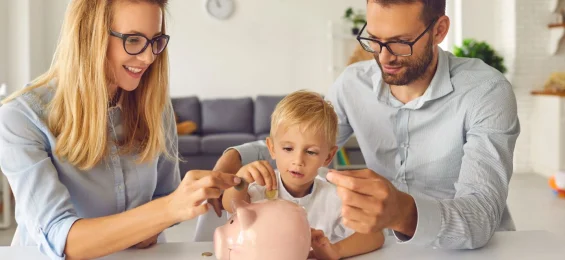 Curious-little-kid-saving-up-money-and-learning-about-financial-literacy-from-young-parents