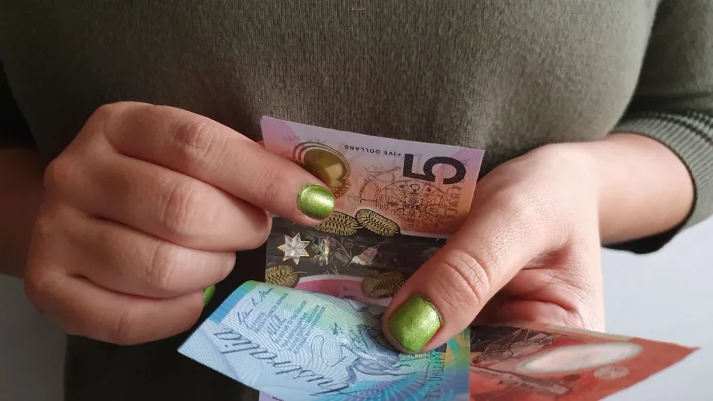 hands-of-a-woman-counting-australian-money