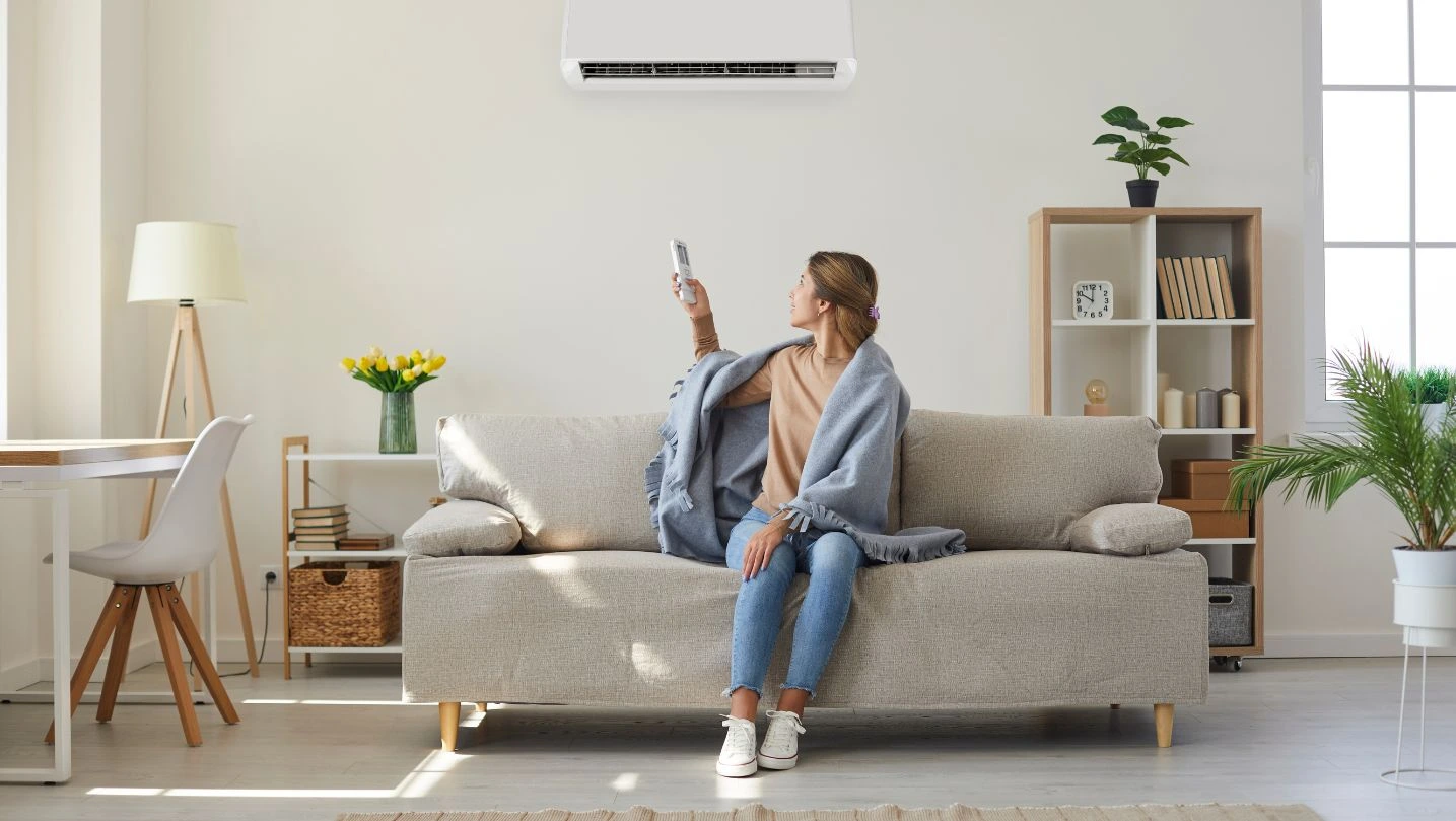 woman-enjoying-cool-fresh-air-in-her-living-room-with-air-conditioner-on-the-wall