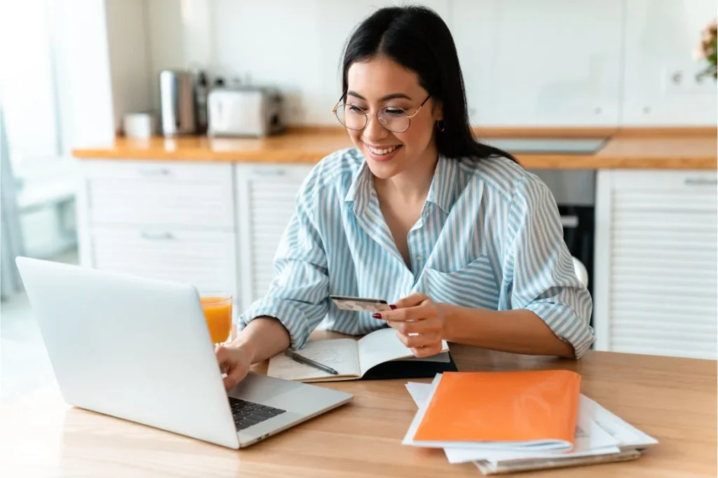 woman-using-laptop-while-holding-credit-card